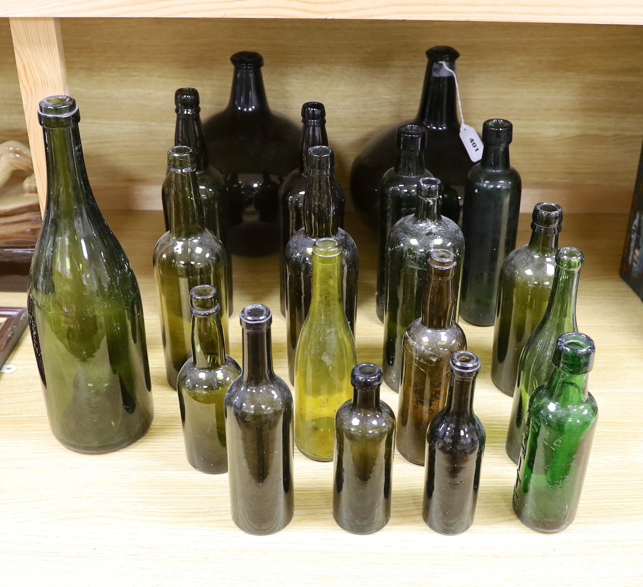 A pair of 18th century green glass onion bottles and a large quantity of other green glass bottles, tallest 38cm